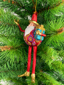 Baumschmuck  Weihnachtsmann mit langen Beinen und einem Geschenk 17 cm rot-gold Christbaumschmuck